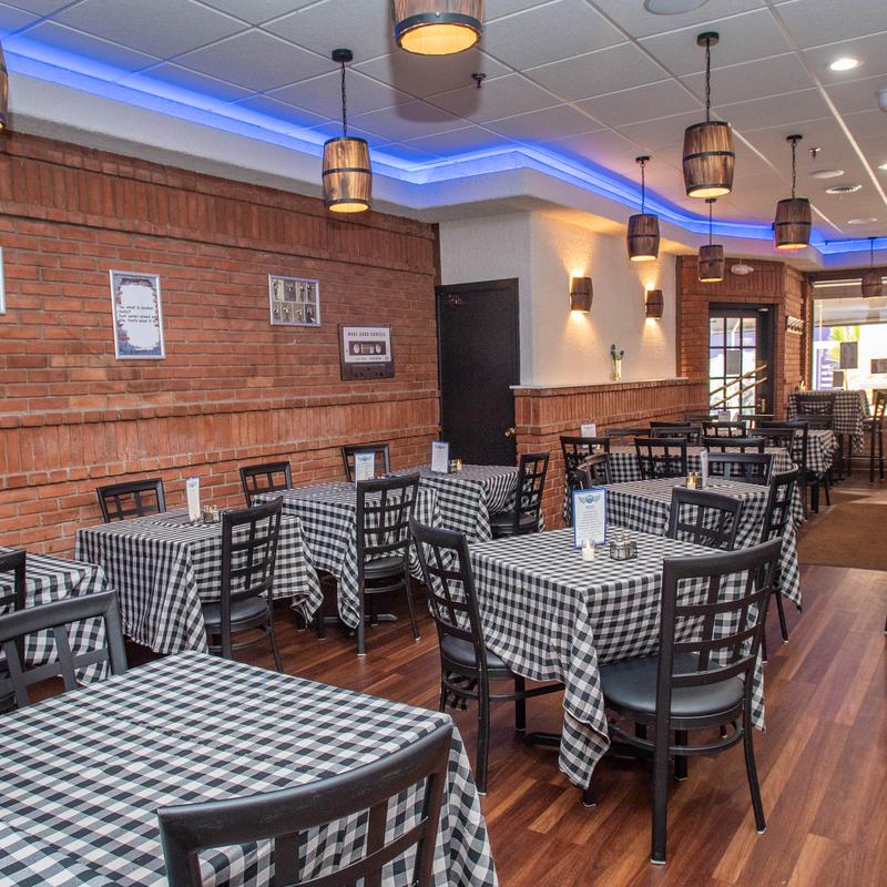 Spitiko’s warm Greektown dining room, with exposed brick and checkered tablecloths